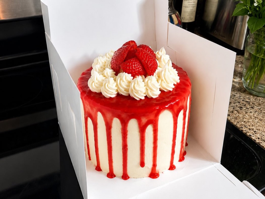 A strawberry layer cake with whipped rosettes and fresh strawberries.