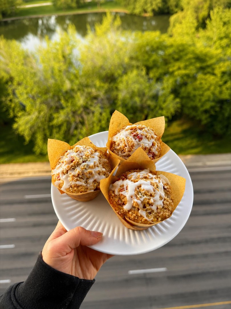Glazed streusel muffins on a plate outdoors.